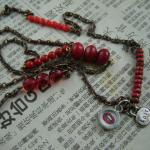 An interspersed assortment of red glass beads  with "lust" charm and "lips" charm.  SOLD