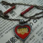 Interspersed czech glass matte red picasso beads with pewter cherub pendant.  SOLD